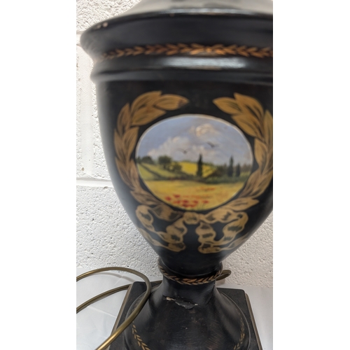 660 - A Pair of Antique Black Painted Urn Shaped Table Lamps Depicting Country Scenes 50cm Tall