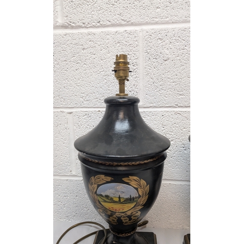 660 - A Pair of Antique Black Painted Urn Shaped Table Lamps Depicting Country Scenes 50cm Tall