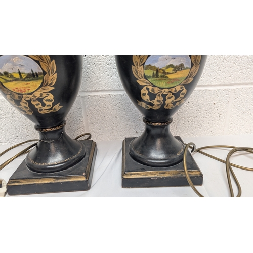 660 - A Pair of Antique Black Painted Urn Shaped Table Lamps Depicting Country Scenes 50cm Tall