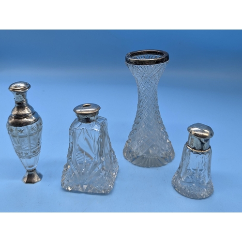 39 - An Assortment of Silver topped Cut Crystal Bottles and Vases