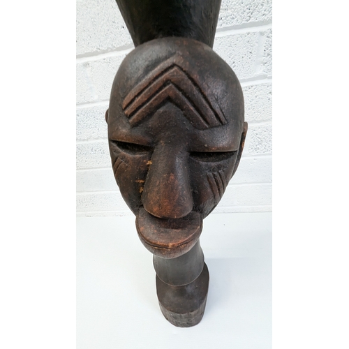 1024 - An African Tribal Drum With Carved Faces Standing 79cm High