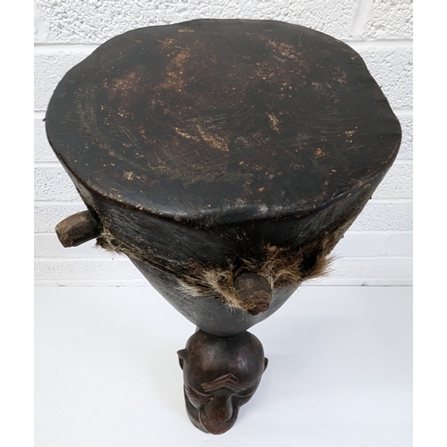 1024 - An African Tribal Drum With Carved Faces Standing 79cm High