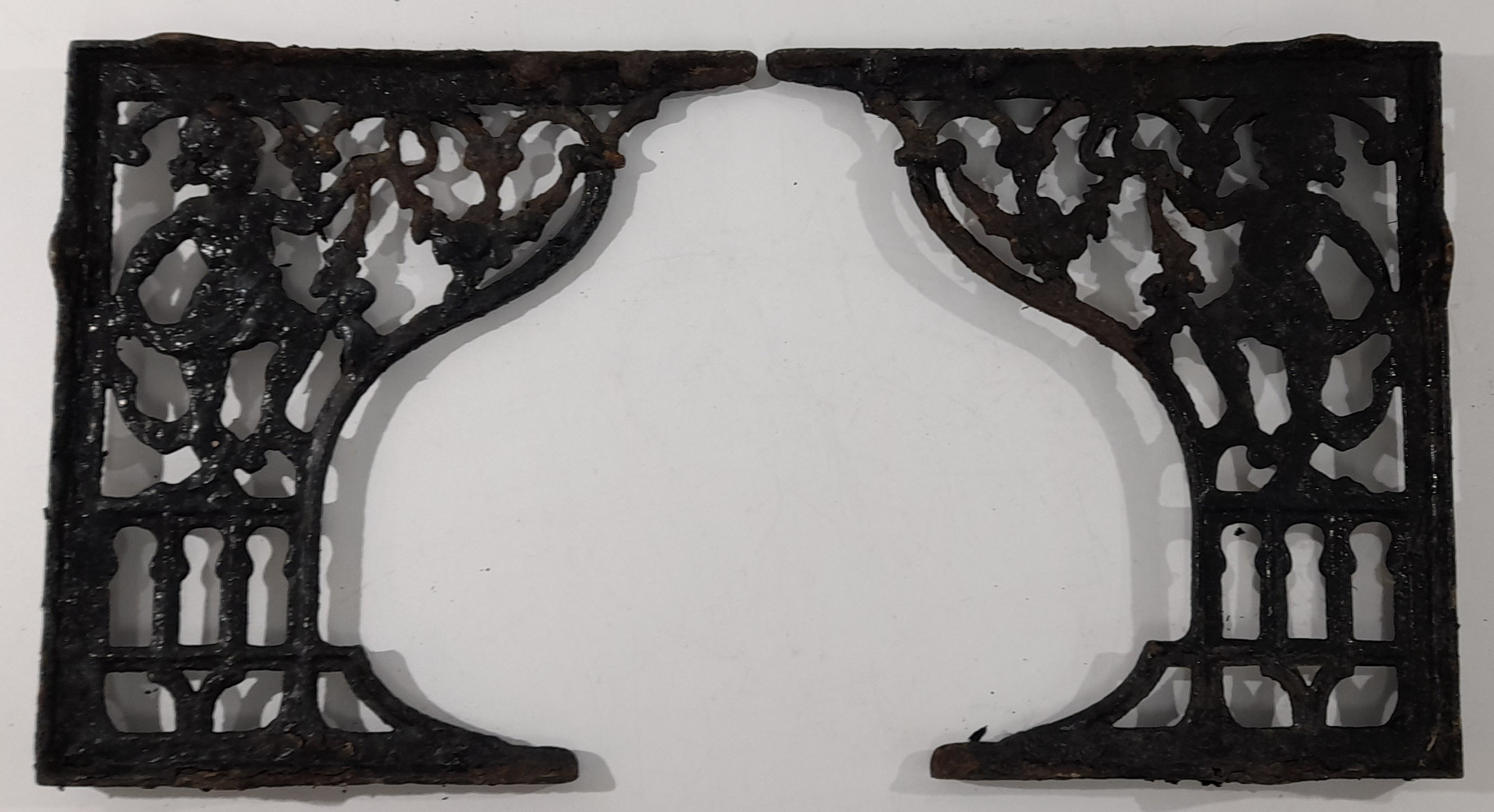 A matched pair of heavy cast iron architectural brackets, each of ...