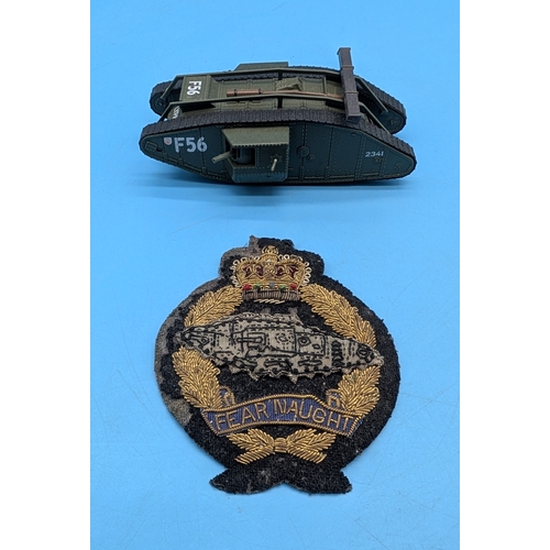 ROYAL TANK CORPS BULLION BADGE AND MODEL TANK

A bullion embroidered Royal Tank Corps badge depicting a tank within a laurel wreath beneath a crown and above the motto &ldquo;Fear Naught&rdquo;, worked in gold and coloured threads on cloth backing, together with a painted die-cast model of a British Mark IV tank named &ldquo;Flypaper&rdquo;, numbered F56.

Badge: inter-war period, circa 1923&ndash;1939.
Model: modern collector&rsquo;s model.

Condition: wear to cloth backing of badge; model in good display condition.