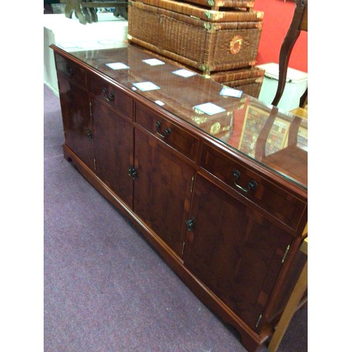 74 - One reproduction four drawer four-door sideboard unit with glass top