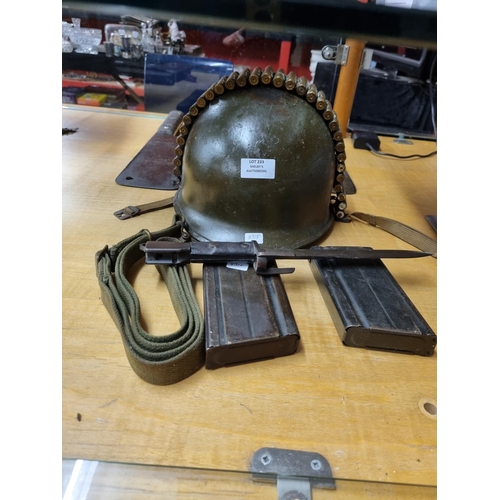 233 - 1 x American helmet ww2 with brass shell clip expelled bullets
1 x belgian type a bayonet with gun m... 