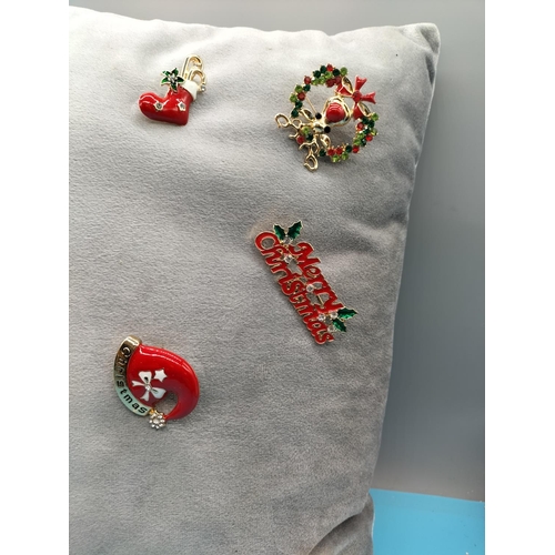 495 - Cushion of Enamel Christmas Brooches.