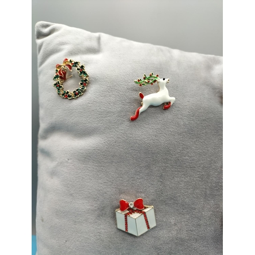 495 - Cushion of Enamel Christmas Brooches.