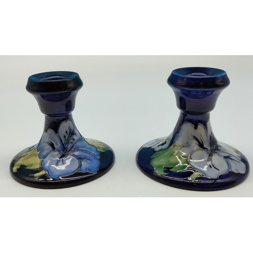 5A - Moorcroft 9cm High Candlesticks (2) in the 'Hibiscus on Blue' Pattern. 10cm Base Diameter.