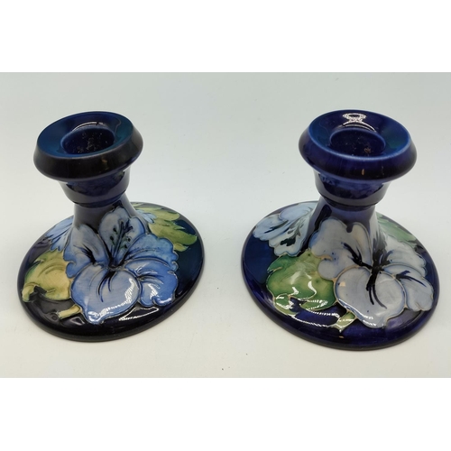 5A - Moorcroft 9cm High Candlesticks (2) in the 'Hibiscus on Blue' Pattern. 10cm Base Diameter.