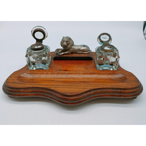 41 - Two Inkwells on Wooden Stand with Lion Design. 13cm High, 40cm x 23cm.