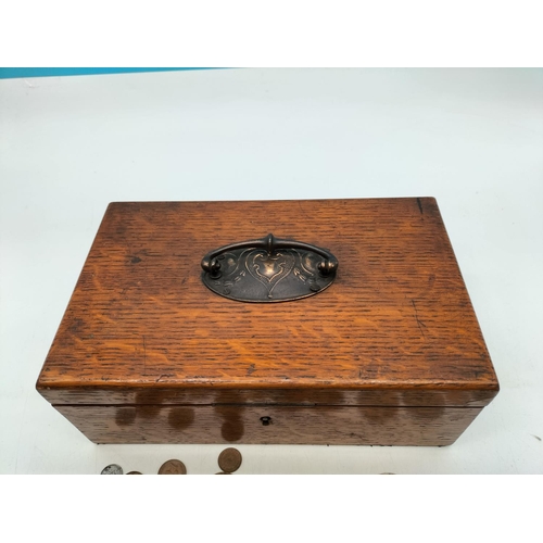 71 - Oak Box with Brass Handle and Quantity of Coins. Requires Key. 11cm High, 27cm x 16.5cm.