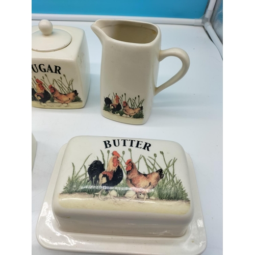 712 - Kitchenware with 'Cock and Hen' design to include Storage Jars, Cheese Dish, Butter Dish, etc.