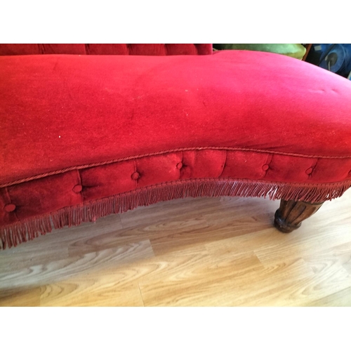 213 - Red Fabric Chaise Longue with Wooden Columned Legs on Castors. One Leg Loose Requires Pinning. lengt... 