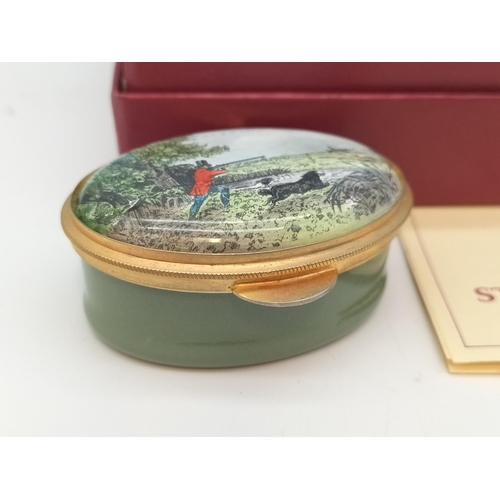 251 - Boxed Staffordshire Enamels Oval Pill Box Decorated with Hunting Scene. 2.5cm high, 5.5cm x 4cm