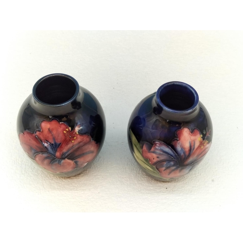 154 - Moorcroft Pottery Hibiscus on Blue Ground Vases (2). Tallest 9cm.