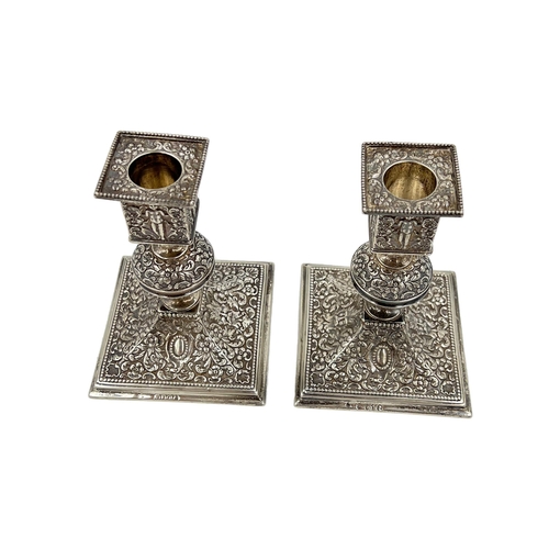 136 - AN UNUSUAL PAIR OF SILVER ENGLISH HALLMARKED CANDLESTICKS DECORATED IN THE INDIAN STYLE, LONODN,1889... 