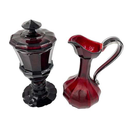 53 - RED ELEGANCE: BOHEMIAN GLASS EWER AND GOBLET DUOThis lot features two Bohemian red glass pieces—a gr... 