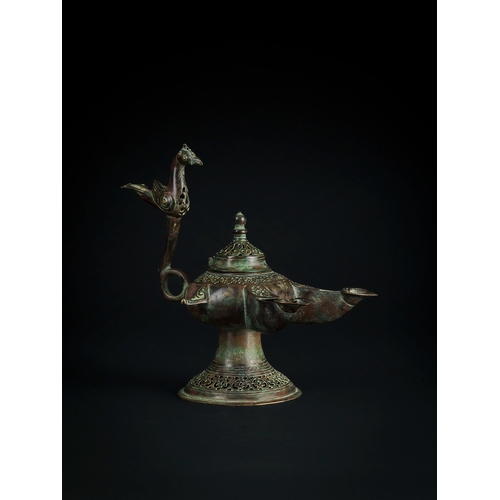 108 - A RARE SELJUK BRONZE OIL LAMP, 11TH - 12TH CENTURY The lamp features a distinct bird motif, with the... 