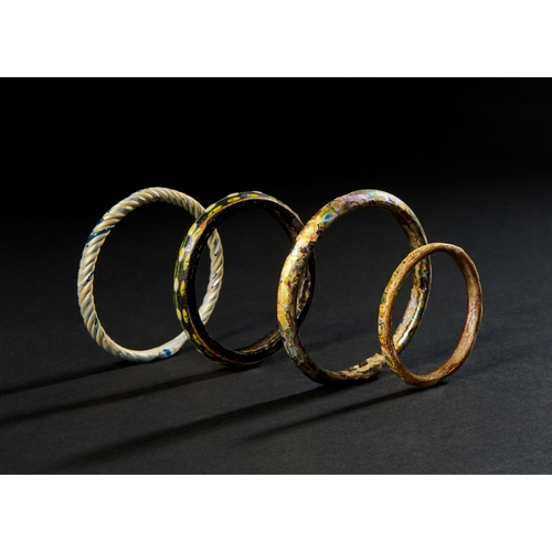 121 - FOUR EARLY ISLAMIC GLASS BANGLES ABBASID CALIPHATE, POSSIBLY SYRIA OR IRAN, 7TH - 9TH CENTURY Set of... 