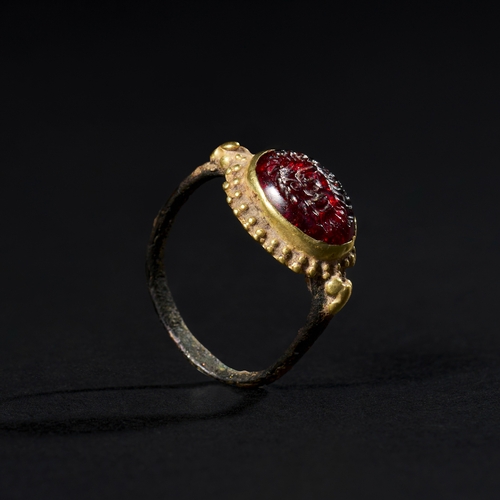 34 - A BRONZE & GOLD SASSANIAN RING WITH ADD ROMAN GARNET INTAGLIO, 3RD CENTURY A unique combination of b... 