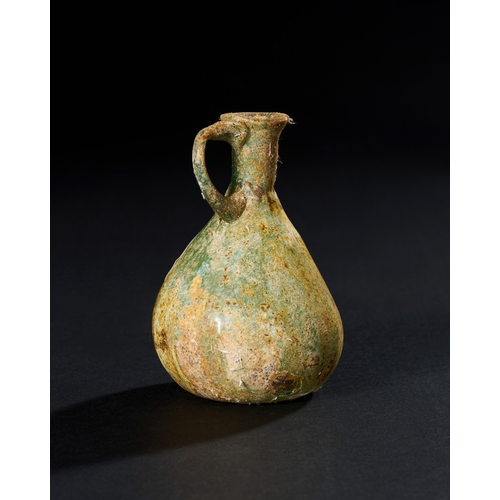 83 - A GREEN ROMAN GLASS EWER, 3RD - 4TH CENTURY A.D. H: 12cm