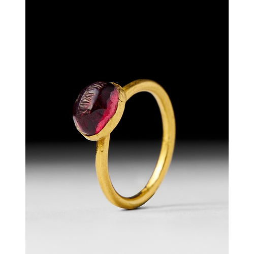 17 - AN ENGRAVED RUBY AND GOLD ISLAMIC SEAL RING This remarkable Islamic seal ring features a beautifully... 