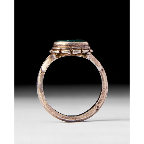 24 - A GREEN STONE ISLAMC SILVER RING, 19TH CENTURY This 19th-century Islamic silver ring features a vivi... 