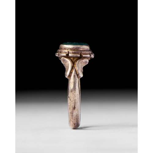 24 - A GREEN STONE ISLAMC SILVER RING, 19TH CENTURY This 19th-century Islamic silver ring features a vivi... 