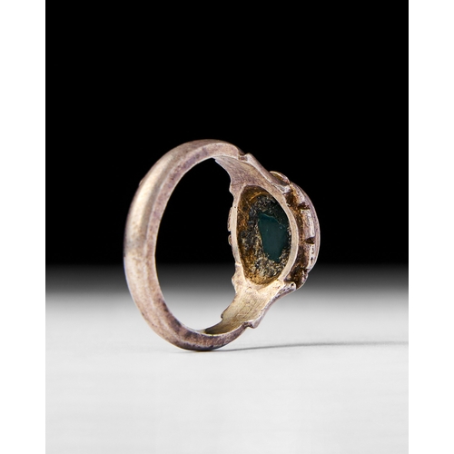 24 - A GREEN STONE ISLAMC SILVER RING, 19TH CENTURY This 19th-century Islamic silver ring features a vivi... 