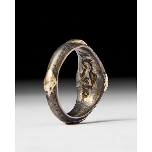 26 - ISLAMIC SILVER AND GOLD INALID RING This Islamic ring featuring a silver band with intricate gold in... 