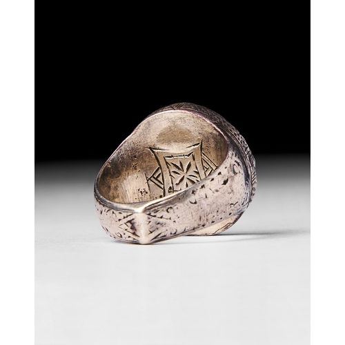 28 - A GOLD ISLAMIC COIN RING SET ON SILVER A gold Islamic coin set into a finely crafted silver band. Th... 