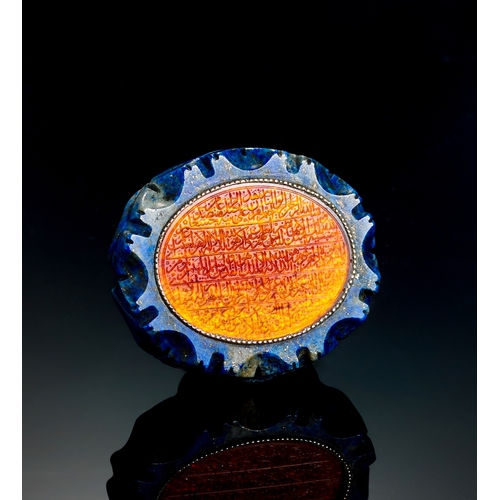 146 - AN ENGRAVED ORANGE ISLAMIC GLASS IN A LAPIS LAZULI FRAME, EARLY 20TH CENTURY  AN ENGRAVED ORANGE ISL... 