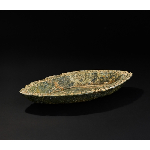 199 - AN EARLY ISLAMIC GREEN HARD STONE BOAT SHAPED DISH A green hard stone  dish is exquisitely carv... 