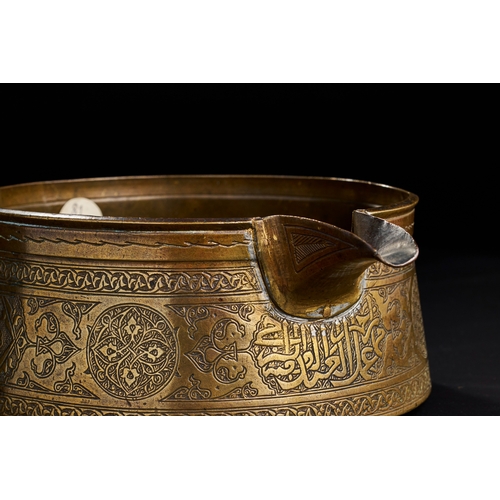 221 - AN ENGRAVED MAMLUK BRASS POURING VESSEL, 15TH CENTURY  A 15th-century Mamluk brass pouring vessel, T... 