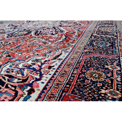 360 - LARGE ANTIQUE HERIZ CARPET, 351 X 250CM  Bold Heriz medallion on a soft red ground with stylish leav... 