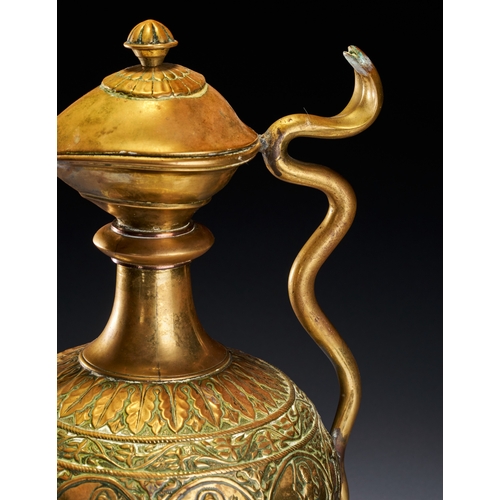 102 - A CHASED BRASS AFTABA EWER WITH SERPENT HANDLE AND HINDU DEITIES, SOUTH INDIA, 19TH CENTURY This Ind... 