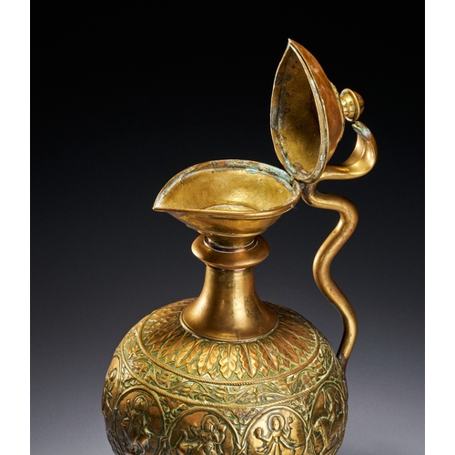 102 - A CHASED BRASS AFTABA EWER WITH SERPENT HANDLE AND HINDU DEITIES, SOUTH INDIA, 19TH CENTURY This Ind... 