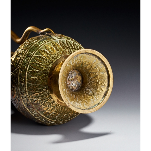 102 - A CHASED BRASS AFTABA EWER WITH SERPENT HANDLE AND HINDU DEITIES, SOUTH INDIA, 19TH CENTURY This Ind... 