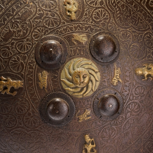 127 - AN INDO-PERSIAN GILT-METAL MOUNTED STEEL DHAL SHIELD, 19TH CENTURY This 19th-century Indo-Persian dh... 