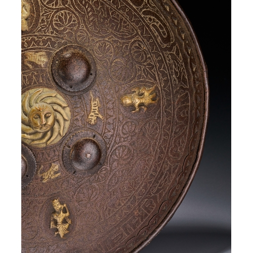 127 - AN INDO-PERSIAN GILT-METAL MOUNTED STEEL DHAL SHIELD, 19TH CENTURY This 19th-century Indo-Persian dh... 