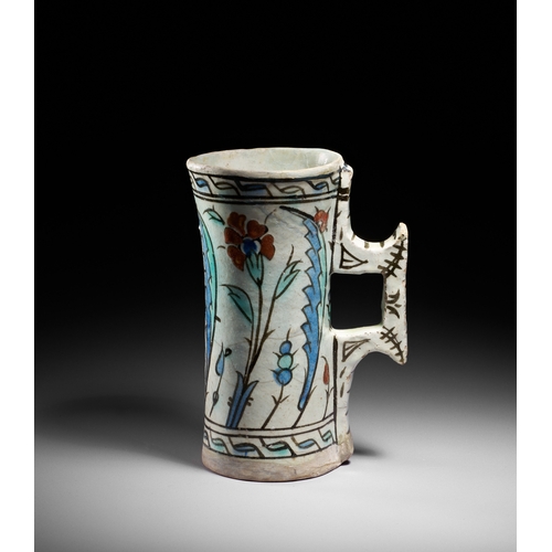 63 - AN IZNIK POTTERY TANKARD, OTTOMAN TURKEY, CIRCA 1600 This finely painted Iznik pottery tankard is a ... 