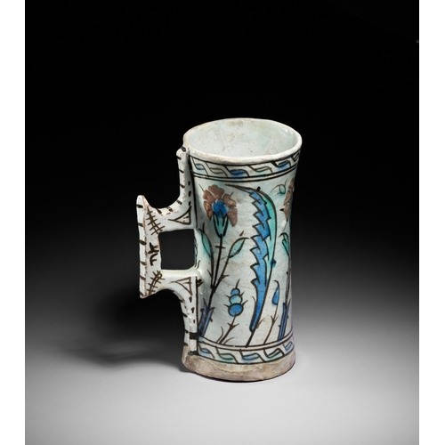 63 - AN IZNIK POTTERY TANKARD, OTTOMAN TURKEY, CIRCA 1600 This finely painted Iznik pottery tankard is a ... 