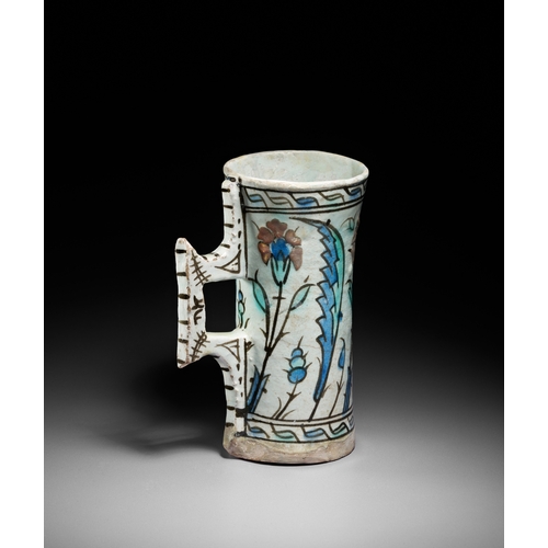 63 - AN IZNIK POTTERY TANKARD, OTTOMAN TURKEY, CIRCA 1600 This finely painted Iznik pottery tankard is a ... 