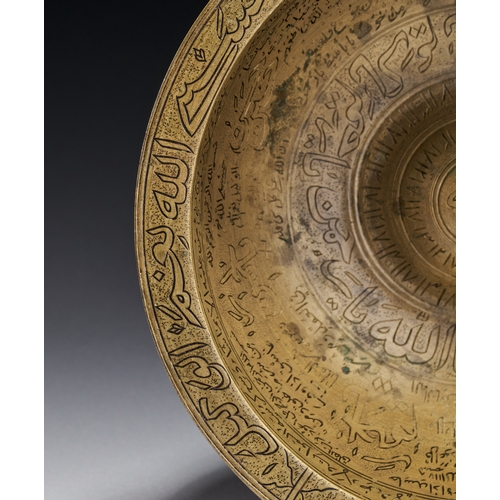 80 - AN ENGRAVED BRASS MAGIC BOWL, INDIA DECCAN, 18TH CENTURY This engraved brass magic bowl is a talisma... 