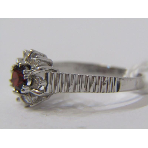 452 - 18ct WHITE GOLD RUBY & DIAMOND CLUSTER RING, principal brilliant cut ruby surrounded by accent brill... 