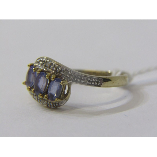 180 - TANZANITE & DIAMOND RING, 9ct yellow gold ring set 3 tanzanite's with diamond shoulders in a cross o... 