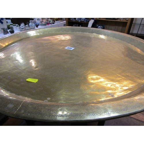 522 - MIDDLE EASTERN BRASS TRAY TABLE, on folding frame, tray 59cm diameter