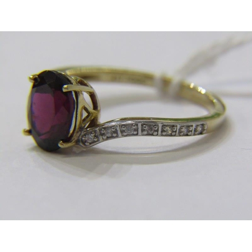 382 - GARNET RING, large oval garnet set on a 9ct yellow gold ring with diamond shoulders of cross over de... 