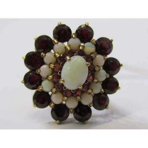 122 - IMPRESSIVE 9ct YELLOW GOLD GARNET & OPAL CLUSTER RING, principal oval cut opal surrounded by a halo ... 